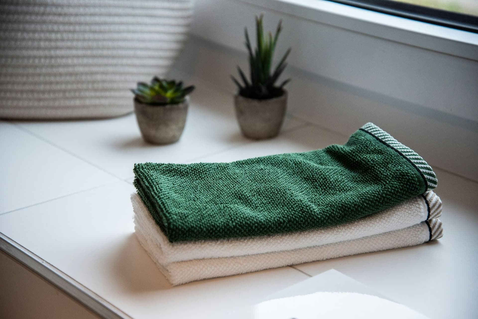 Uredno složeni peškiri pored saksija sa biljkama